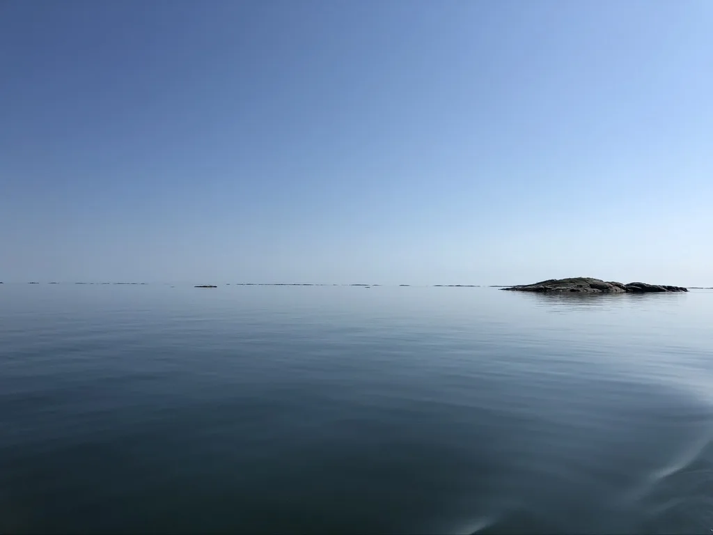 Stilla svensk skärgård med skär och öppen horisont en klar sommardag
